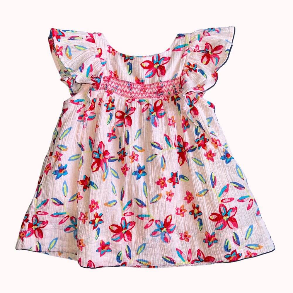 Robe d’enfant en tissu crêpe à motifs floraux colorés, avec manches volantées, boutons dans le dos et doublure intégrée, en très bon état.