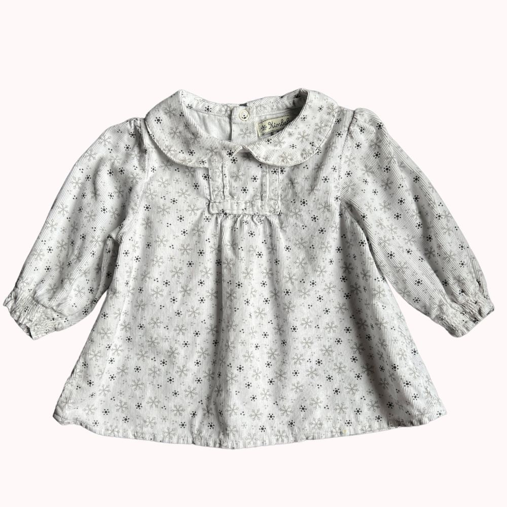 Blouse à manches longues pour enfant, imprimé délicat, col claudine, et fermeture boutonnée dans le dos, en très bon état.