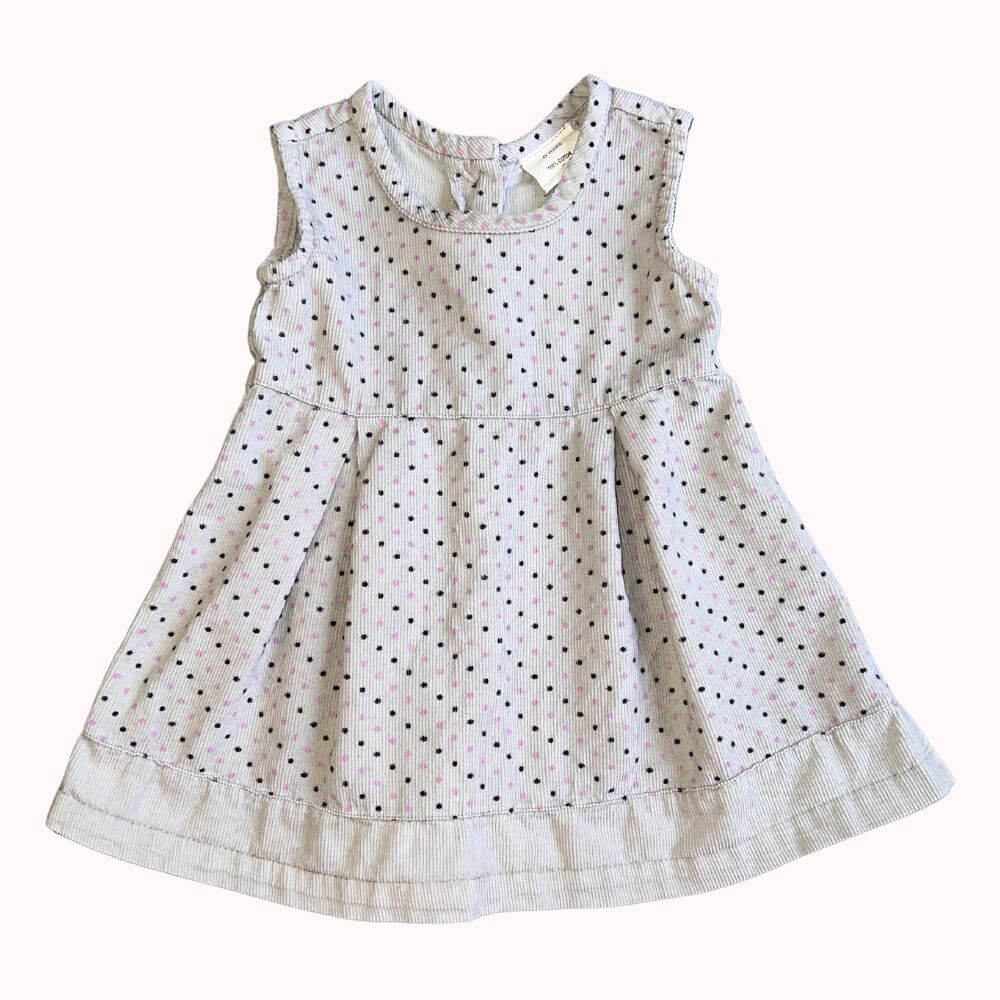 Robe à pois pour enfant, sans manches, avec coupe évasée et boutons dans le dos, en très bon état.