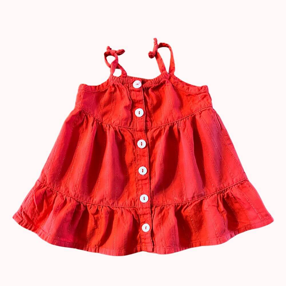 Robe bébé rouge Orchestra en coton, à bretelles nouées, légèrement pailletée, coupe évasée à volants, fermeture par boutons blancs sur le devant, taille 3 mois.