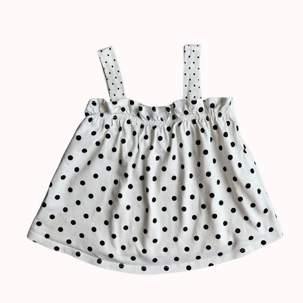 Blouse d’été blanche à pois noirs, bretelles larges, encolure froncée, tissu léger, taille 7 ans.