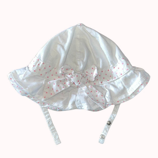 Chapeau de soleil blanc pour bébé avec liseré et nœud à pois roses, marque Orchestra, taille 44 cm, avec brides de fermeture.