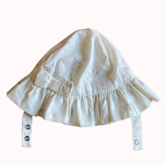 Chapeau de soleil écru pour bébé, avec nœud décoratif et petits motifs brodés, marque Orchestra, taille 34 cm, fermeture par brides à pressions.