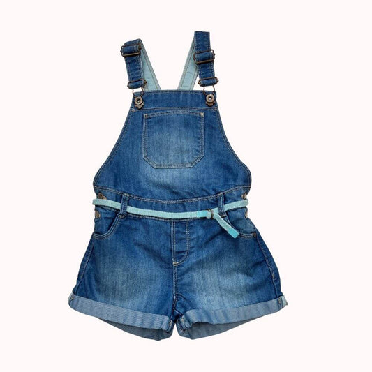 Combishort en jean Okaïdi avec bretelles réglables, ceinture tressée et revers aux jambes, coupe décontractée.