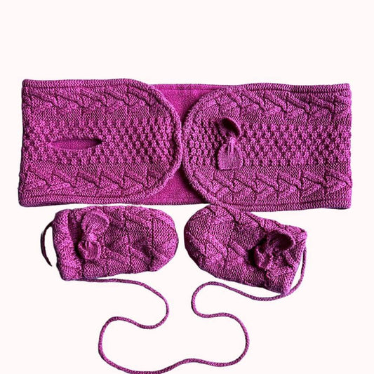 Ensemble bébé en tricot framboise comprenant un chauffe-épaules avec pompons et une paire de moufles à liens, pour ne pas les perdre en bon état.