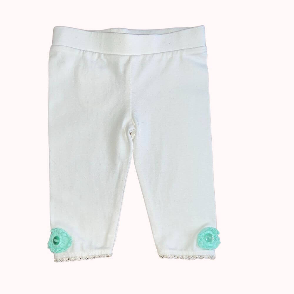 Legging écru pour bébé 3 mois avec fleurs en tissu bleu et dentelle aux chevilles.