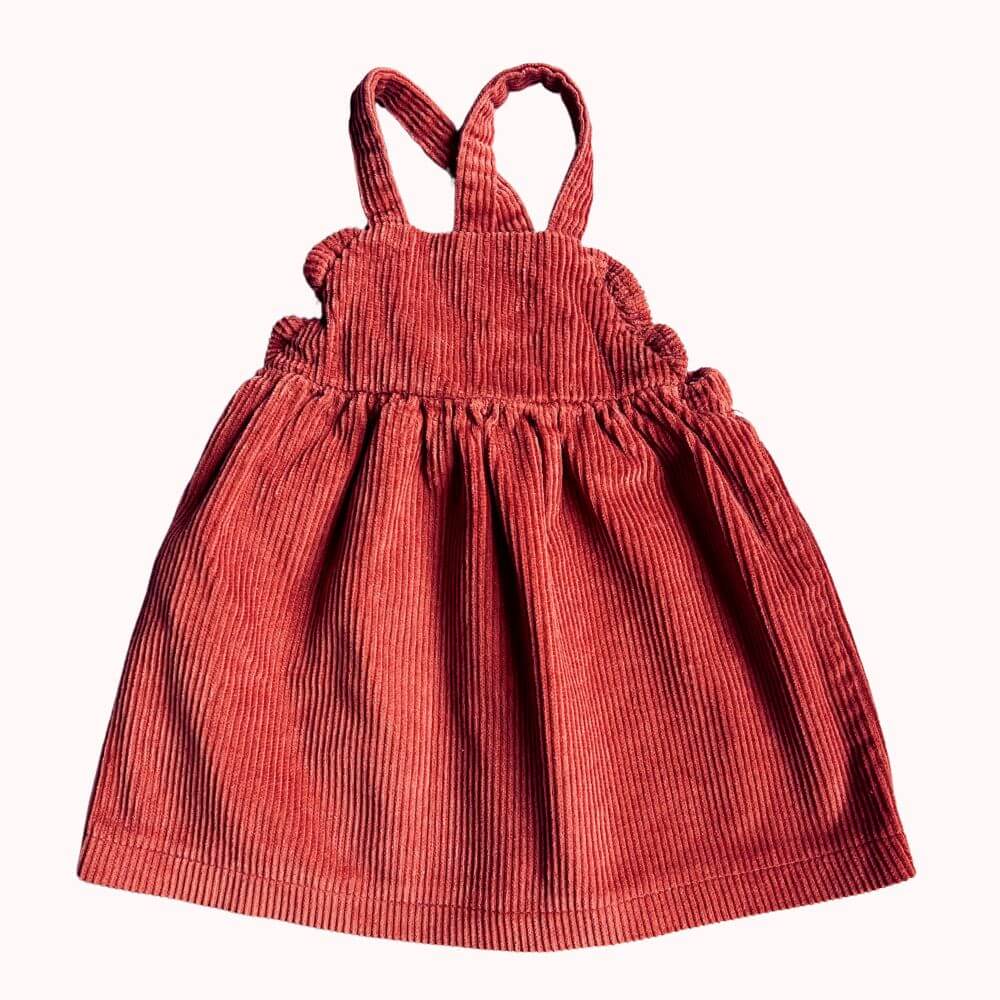 Robe à bretelles en velours côtelé couleur brique Kiabi pour bébé 6 mois, avec volants sur les côtés.