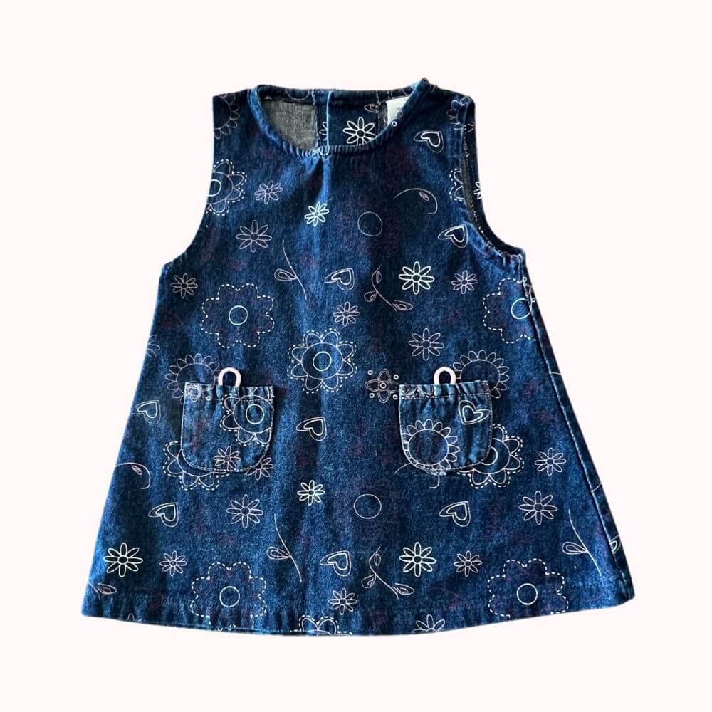 Robe chasuble en velours bleu marine, motif fleuri et cœurs blancs, avec deux petites poches sur le devant, taille 6 mois.