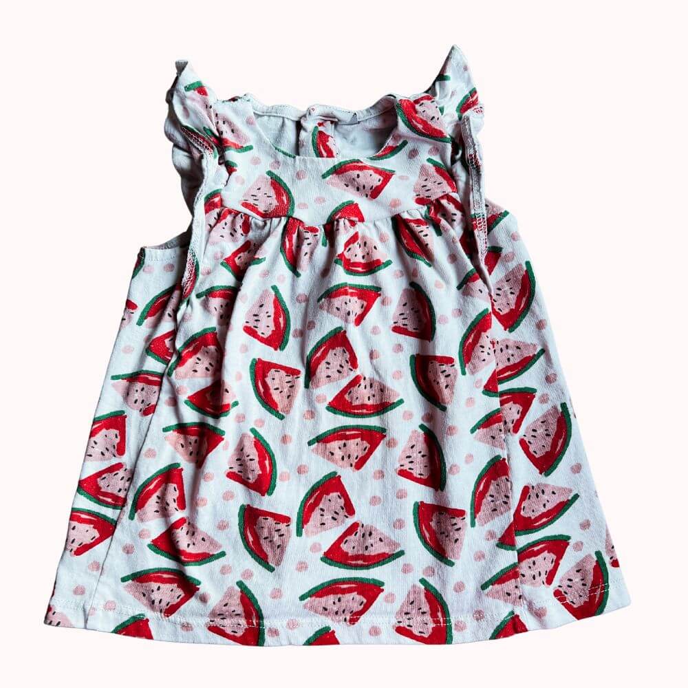 Robe d’enfant sans manches avec imprimé pastèques, volants sur les épaules et boutons dans le dos, en bon état.