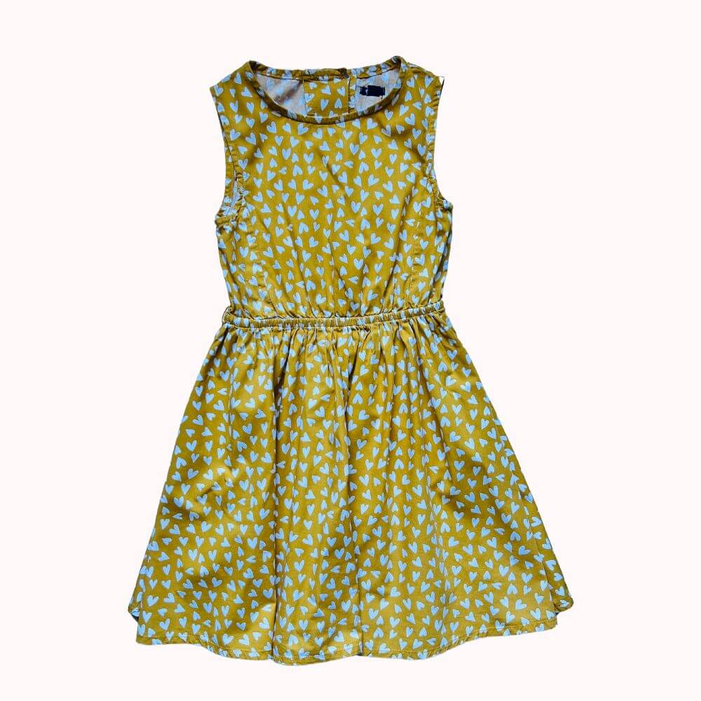 Robe sans manches jaune ocre à imprimé cœurs bleus, taille élastiquée et fermeture boutonnée au dos.