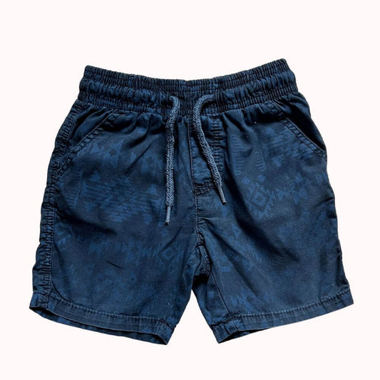 Short bleu marine enfant, avec motifs discrets ton sur ton, taille élastiquée et cordon de serrage, tissu léger et confortable.