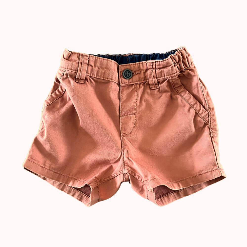 Short bébé 12 mois H&M en coton terracotta, coupe droite, taille élastiquée au dos, poches latérales et fermeture par bouton.
