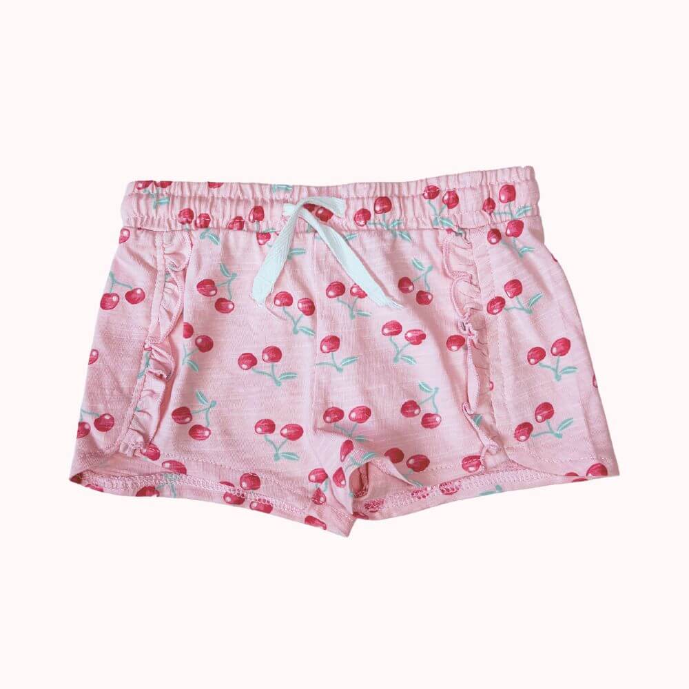 Short Orchestra rose avec imprimé cerises, volants sur les côtés et taille élastiquée, en taille 12 mois.