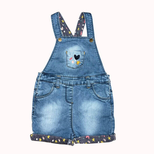 Salopette short en jean bleu pour bébé fille Orchestra 18 mois avec motifs étoiles et cœur brodé, portée avec un collant, vêtement enfant de seconde main.