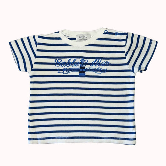  T-shirt marin à rayures bleu marine et blanches pour enfant, avec broderie "Sable &amp; Mer" et phare, manches courtes et pressions à l’épaule.