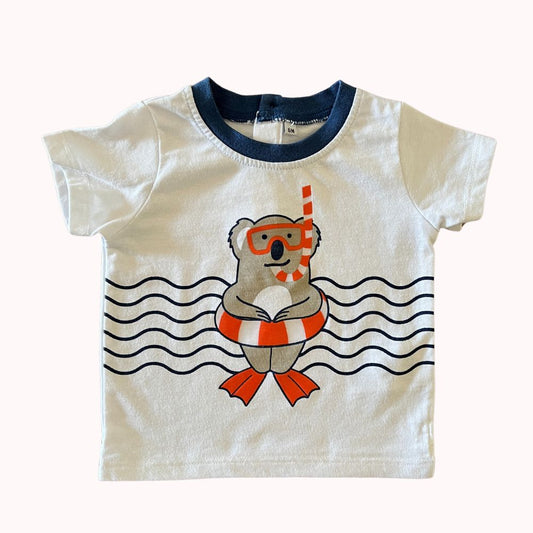 Tee-shirt bébé blanc, taille 6 mois, avec dessin de koala en palmes et tuba sur fond de vagues, col bleu marine.